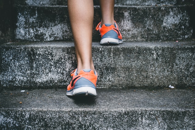 Feet in colourful trainers climbing stone steps