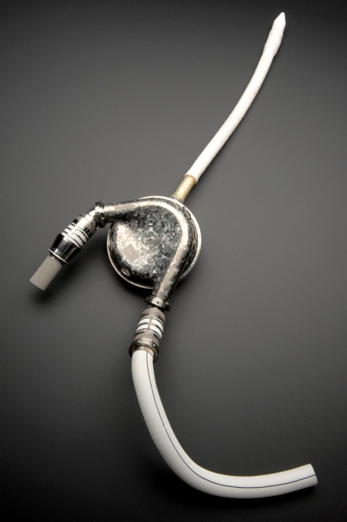 A silver-coloured disc with three tubes coming out of it.