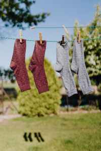 Two pairs of socks attached to an outdoor washing line with clothes pegs.