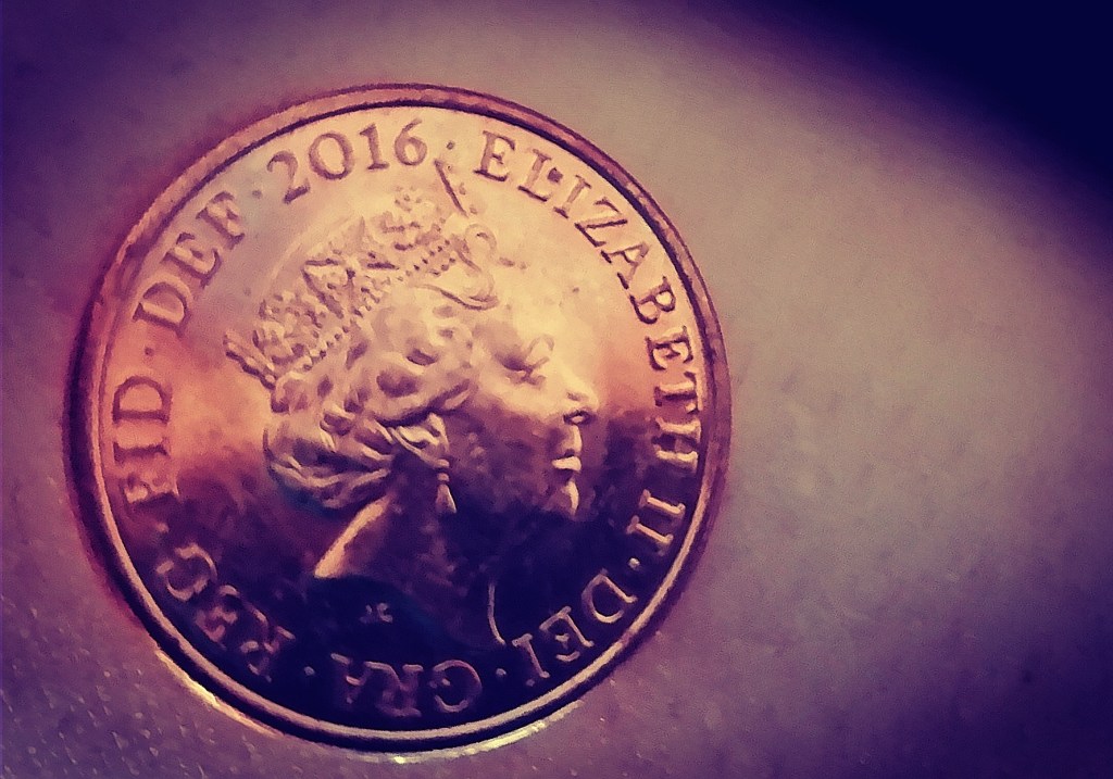 The queen's face on a 1p piece next to a very tiny white scar, approximately 3mm long. The photo has filters applied to make the scar more visible.